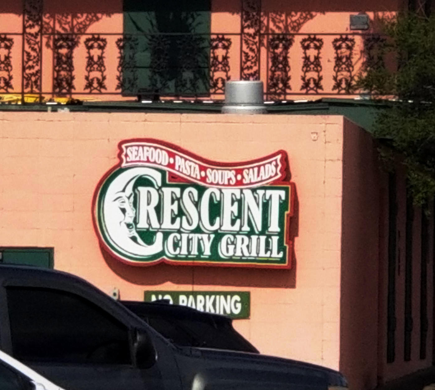Restaurant sign showing a smiling cresent moon and the words Crescent City Grill, Seafood, Pasta, Soups, Salads.