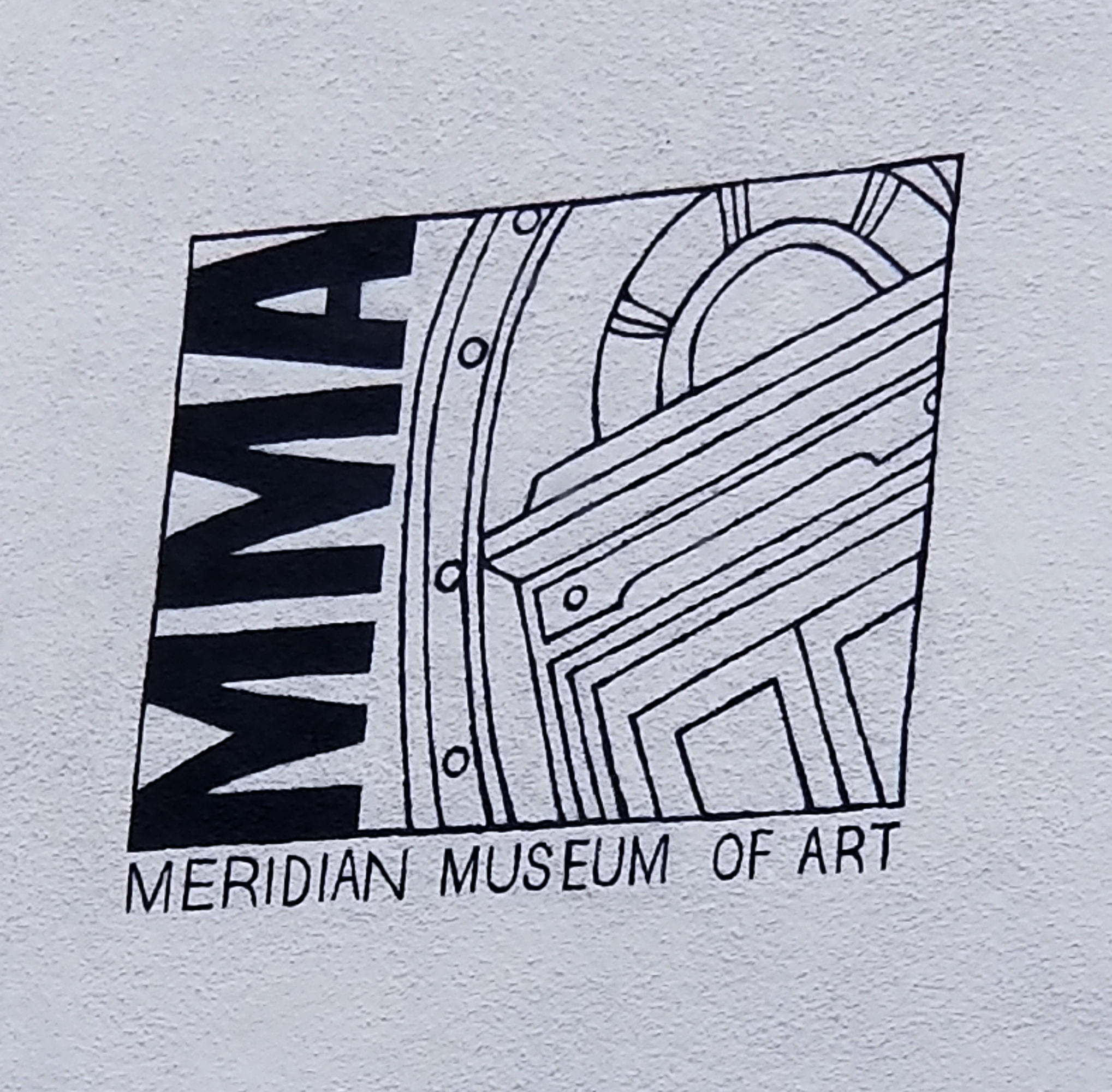 A sign identifying the Meridian Museum of art and portraying the top of a door.