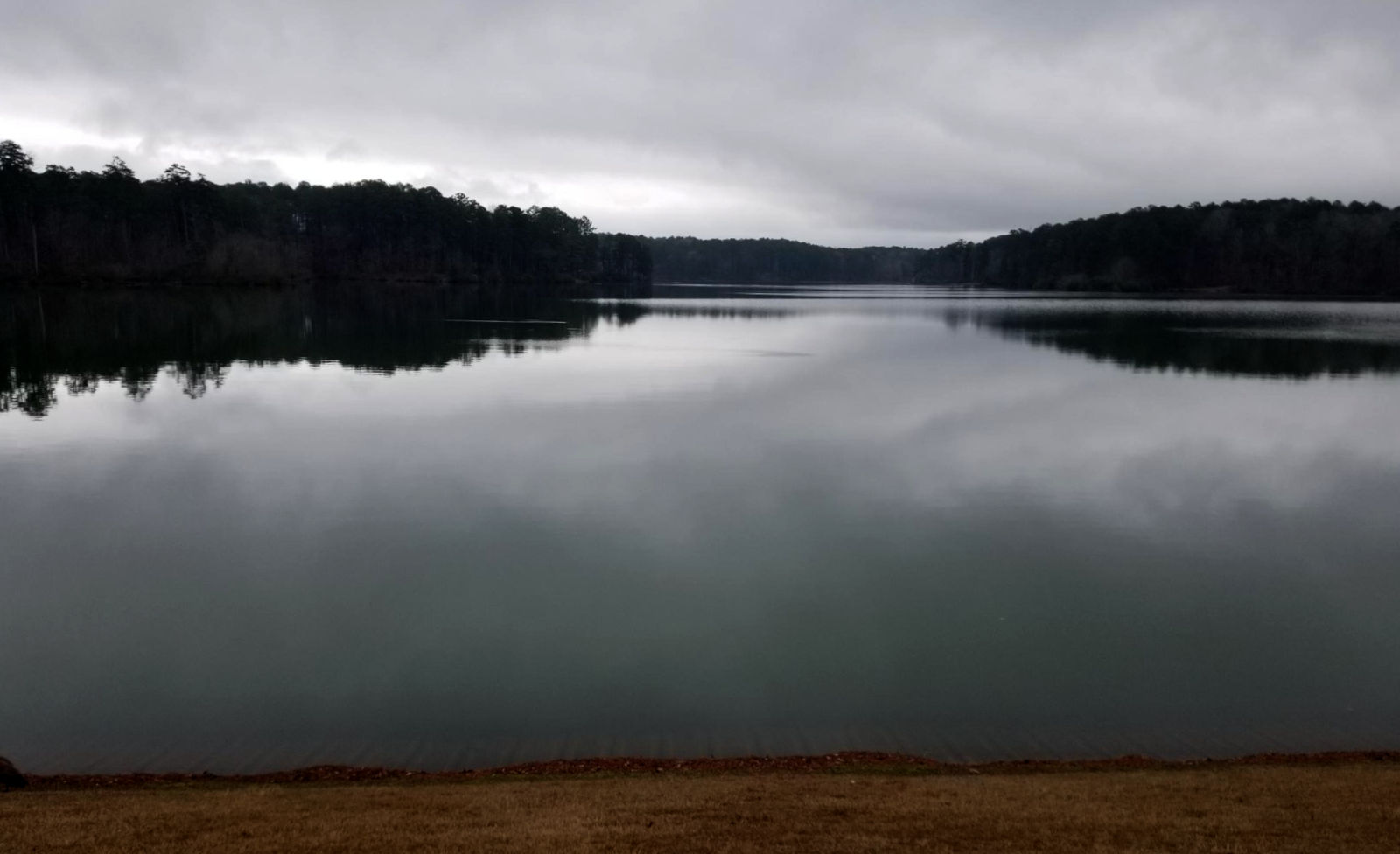 Grey clouds reflected on the surface of a lake.
