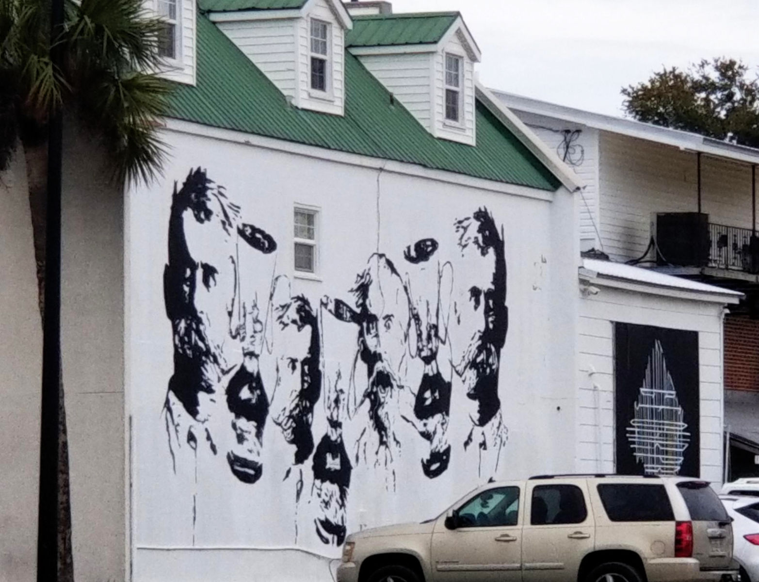 A mural in black against the white wall of Mary Mahoney's restaurant shows an array of men's faces sporting epic mustaches.