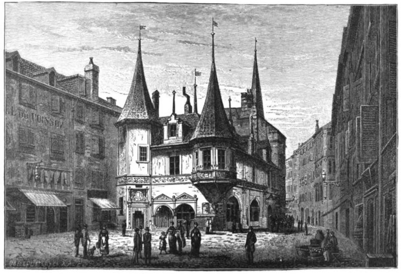 Pedestrians are seen in a city center, featuring a building surrounded by other buildings.