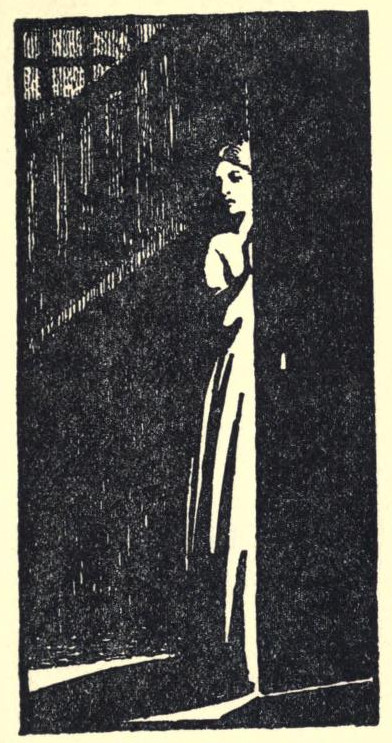 A woman is seen in front of stairs half concealed by a door.