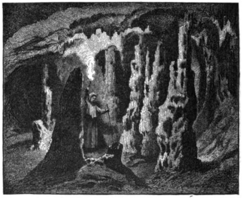 A lone figure is seen illuminating a cavern with a torch.