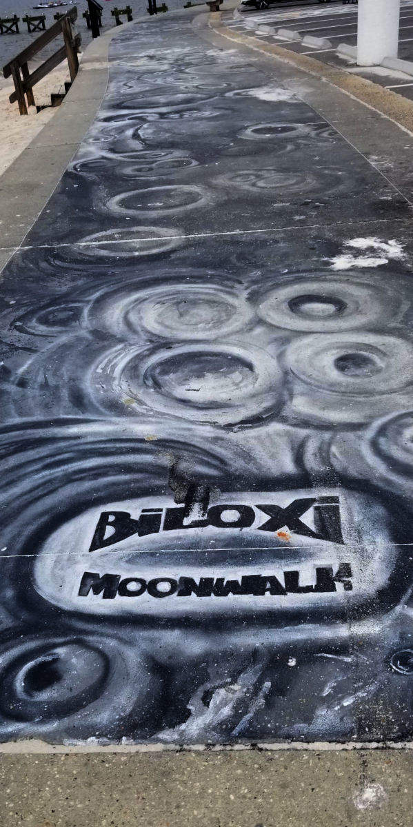 Painting on the sidewalk, Biloxi Moonwalk, looks like the moon.