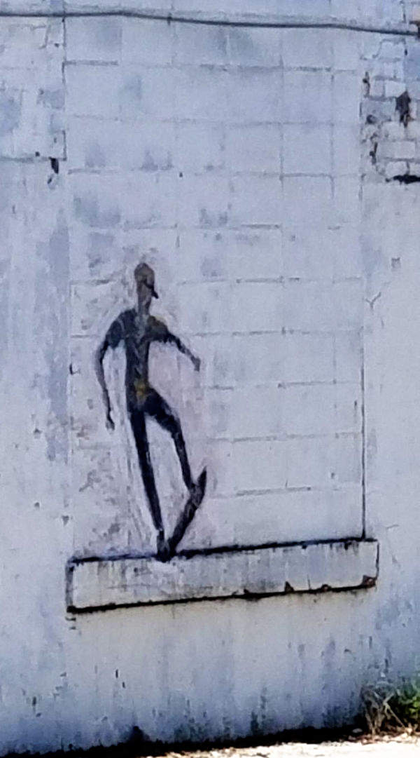 Blokita fenestro en blankan konstruaĵon, natura spaco por strata arto montranta rultabuliston.