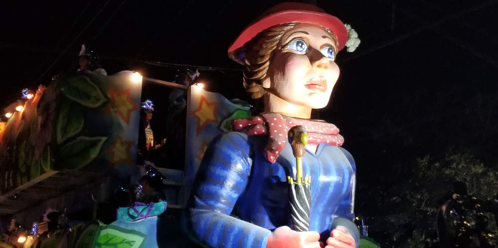 Paradĉaro kun figuro de virino kun ruĝa ĉapelo kaj ombrelo.