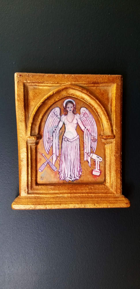 Under a gold gothic arc, an angel, crossed screwdrivers, and cordless drill.
