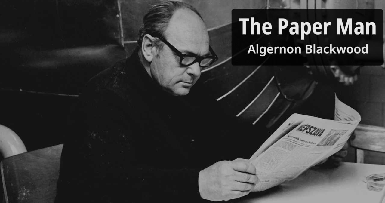 Bespectacled man reads his newspaper.