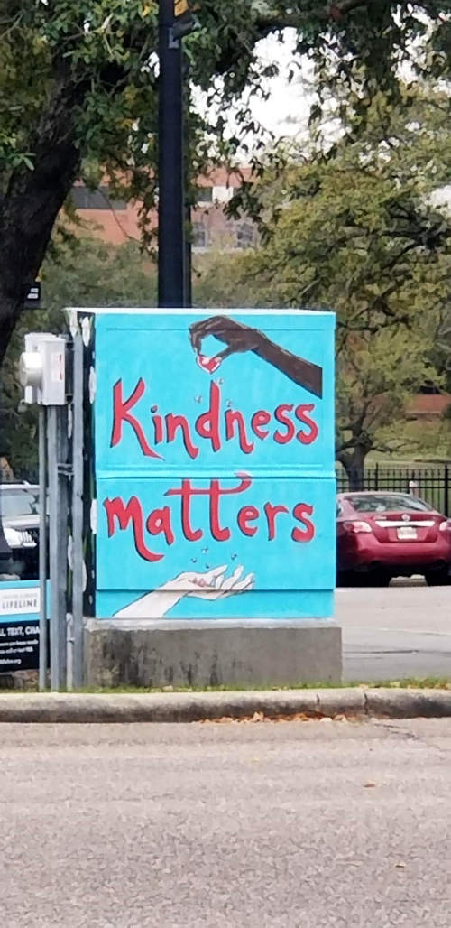 Painting on a metal box, two hands, kindness matters.
