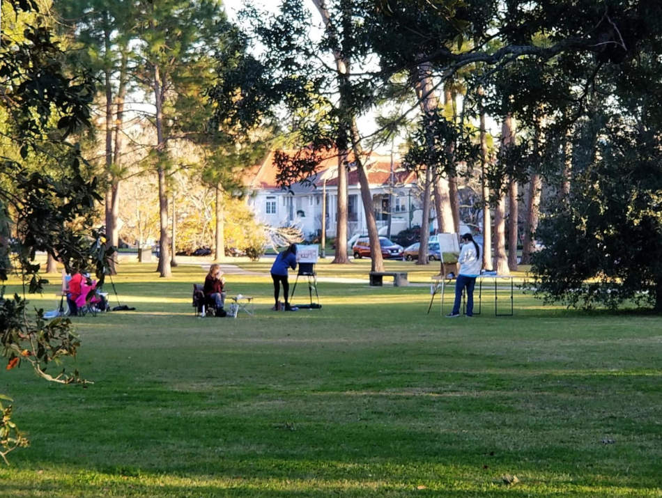 Kvar pentristoj pentras en publika parko en Nov-Orleano.